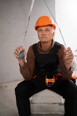 Kasklı ve tulumlu üst düzey müteahhit inşaat sektöründe kamera uzmanlığına bakıyor. kopyalama alanı. meslek, inşaat ve onarım kavramı.