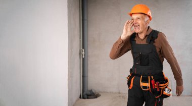 Güvenlik miğferi takmış tamirci ya da tamirci bağırarak duyuru yapıyor ya da yenileme işlemi sırasında inşaat alanında iyi haberler veriyor. Daire onarımı ve yenileme konsepti.