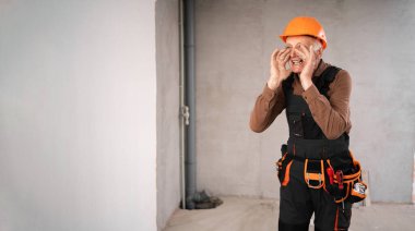 Güvenlik miğferi takmış tamirci ya da tamirci bağırarak duyuru yapıyor ya da yenileme işlemi sırasında inşaat alanında iyi haberler veriyor. meslek, inşaat ve onarım kavramı.