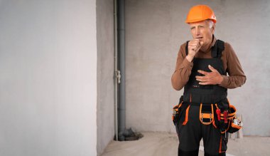 İnşaat işçisi ya da güvenlik kaskı takan yaşlı bir tamirci, hasta, öksürük, soğuk algınlığı, tadilat sırasında inşaat alanında. meslek, inşaat ve onarım kavramı.