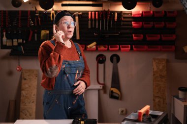 Evreka. Tulumlu ve gözlüklü kadın tamirci, tamirhanede çalışırken iyi bir fikir için heyecanla hareket ediyor. Boşluğu kopyala