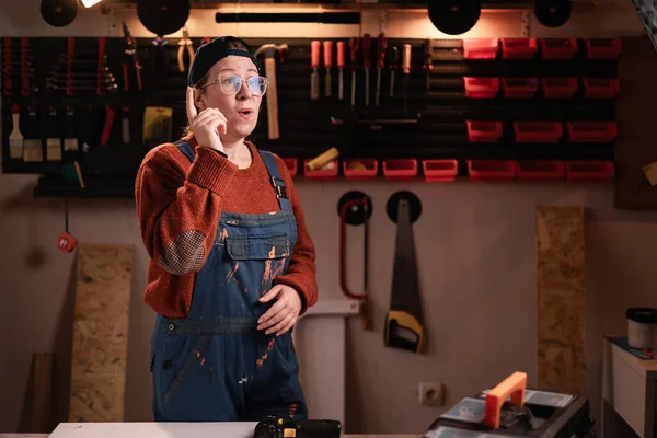 Evreka. Tulumlu ve gözlüklü kadın tamirci, tamirhanede çalışırken iyi bir fikir için heyecanla hareket ediyor. Boşluğu kopyala