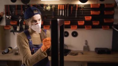 Mobilya detaylarını boyayan koruyucu maske takan bir kadın. Boyacı boya ve boya fırçasıyla mobilya tadilatı yapıyor. Boşluğu kopyala