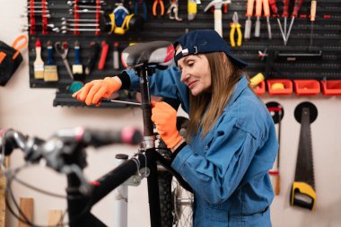 Bisiklet tamirhanesinde ya da tamirhanede çalışan orta yaşlı bir kadın. Tamirci profesyonel tamirci servis alanında. Başlangıç, küçük işletme konsepti