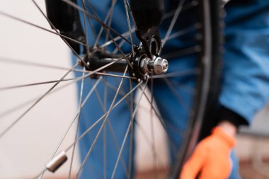 Bisiklet tekeriyle ilgilenmeye yakın çekim. Bisiklet dükkanında tamirat. Atölyede tamirci.