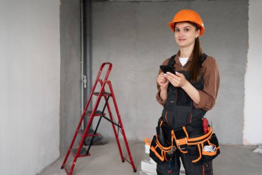 Kadın İnşaatçının Portresi. İnşaat alanında kadın inşaat işçisi. Teknoloji, onarım, inşaat ve inşa konsepti. Boşluğu kopyala