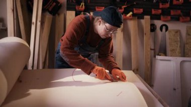 Koltuk ya da kanepe tadilatı için köpük dolgu malzemesi kesen kadın mobilya restoratörü. Döşeme, eski kanepe ya da koltuk tamiri kavramı