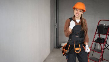 Kadın Mimar. Kızgın Saldırgan Kadın Mimar bitmemiş binada yumruk yumruğa duruyor. Onarım, inşaat ve inşaat konsepti. Pankart. Boşluğu kopyala