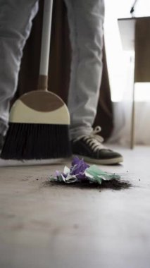 Ev temizliği konsepti. Süpürge ve süpürge ile ev işi, yakın plan. dikey video