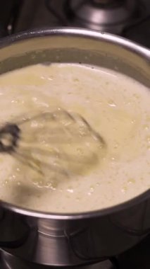 Fırının üstünde bir tencerede krema çırpan şekerleme makinesini kapat. Geleneksel Fransız hamur işlerini adım adım pişir..