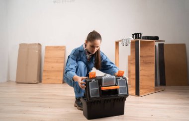 Mobilya montajı için alet çantasındaki aletleri açan kadın. Boşluğu kopyala