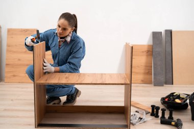 Profesyonel mobilya derleyicisi modern mutfağa ahşap dolaplar ve dolaplar kuruyor. Mobilya montaj kavramı.