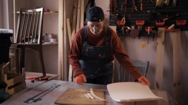 Konsantre kadın restoratörü, antika ahşap mobilyaları tamir ederken, profesyonel restorasyon atölyesinde, klasik atmosferde çalışıyor..