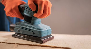 Ahşap yüzey işi için zımpara kağıdı kullanan bir marangozun kapağını kapat. Profesyonel marangozluk süreci ve kereste tedavisi.