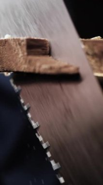 Tahtadaki el testeresinin yakın çekimi. Marangozluk aleti. dikey video