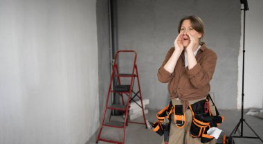 Afro-Amerikan bir adam evini yenilemek için çalışıyor. Çok mutlu ve heyecanlı. Kolları havada, gülümseyen ve başarı için bağıran kazanan bir jest yapıyor. kutlama konsepti.