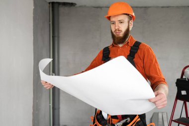 İnşaat işi. Foreman inşaat halinde. Planları olan bir inşaatçı. Boşluğu kopyala