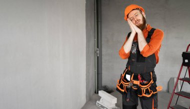 İnşaat alanında gece hareketlerini gösteren yorgun gözlerle uyuyan genç müteahhit. Boşluğu kopyala