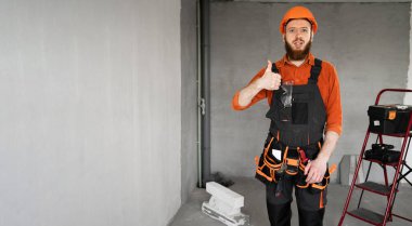 Güvenlik kasketi takmış erkek müteahhit inşaat alanında el hareketi yapıyor. Pankart. Boşluğu kopyala