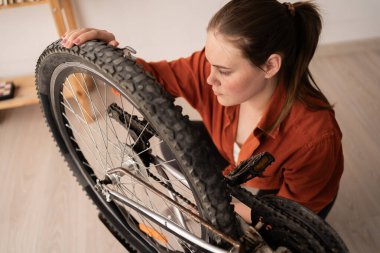 Kadın arka tekerlek adaptasyonu. Yatak odasında bisikleti olan bir tamirci. Boşluğu kopyala