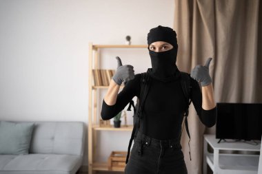 Siyah kar maskeli hırsız ya da soyguncu terörizm suçlusu evde para çalıyor. Sevimli hareketler yapıyor ve kameraya bakıyor. Boşluğu kopyala