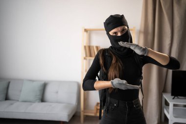 Hırsızlık ve suç. Ölçüm Kavramı. Hırsız ya da davetsiz misafir kadın siyah kar maskesi takmış, elleri büyük ve büyük gösteriyordu. Boşluğu kopyala