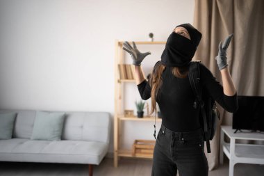 Hırsızlık ve suç kavramı. Kızgın hırsız ya da davetsiz misafir kadın silahlı siyah kar maskesi giyiyor. Boşluğu kopyala