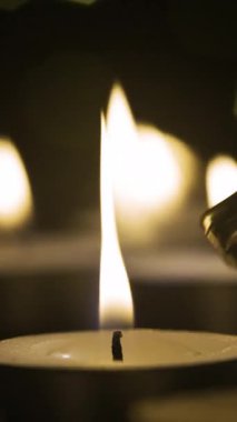 Çakmak küçük mum yakar. Siyah arka planda mum yakmak. dikey video