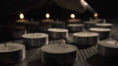 Büyük çakmaktan yanan küçük mumların yakın çekimi. Makro