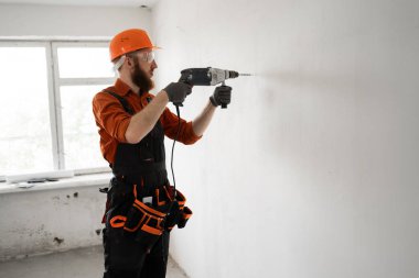 İnşaat işçisi sakallı adam inşaat alanında çekiç talimi yapıyor. Tamirci ev tamiri yapıyor. Profesyonel müteahhit içeride. Boşluğu kopyala