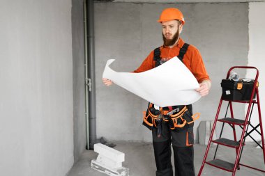 İnşaat işçisi sakallı adam inşaat alanında planlı. Tamirci ev tamiri yapıyor. Profesyonel müteahhit içeride. Boşluğu kopyala