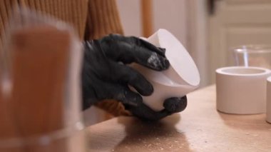 Adam, silikon kalıptan el yapımı alçı mum tutacağı ayıklıyor. Atölyede alçıtaşı ev dekorasyonu yapmak için yaratıcı bir yöntem. DIY zanaat ve hobi konsepti.