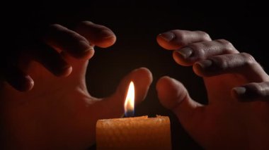 Adam mumun üzerinde sıcak eller ısıtma ve elektrik olmadan. Enerji krizi konsepti. yakın plan