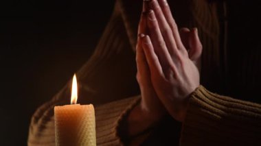 Yakından yanan bir mumla dua eden bir adam. Din kavramı