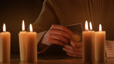 Falcı eller mumların altında tarot kartlarında falcılık yapıyor. Yakın plan.
