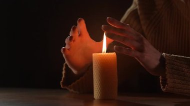 Adam mumun üzerinde sıcak eller ısıtma ve elektrik olmadan. Enerji krizi konsepti. yakın plan