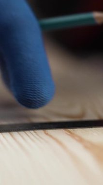 Ahşabı kurşun kalem ve cetvelle işaretleyen marangoz ellerini kapatın. Ölçüm, marangozluk ve marangozluk kavramı. dikey video