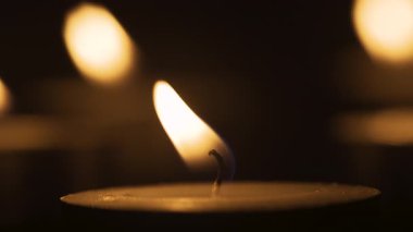 Makro Dof yanan mum. Sıcak mum ışığı, alev ve fitil. Karanlık arka planda atmosferik parlayan ışık. Yakın plan.