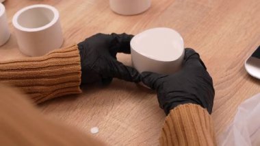 Sanatçının ellerinin alçıtaşı silikon kalıba dökerek şamdan yapmasını. DIY, hobi ve el yapımı işçilik kavramı. Küçük atölyede yaratıcı süreç.