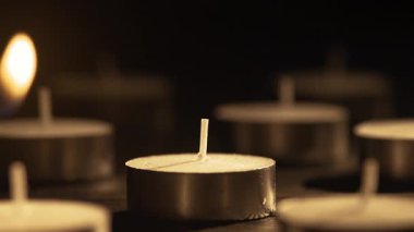 Çakmak, zifiri karanlıkta küçük çay ışıkları mumları yakıyor. Yakın plan. Romantik konsept