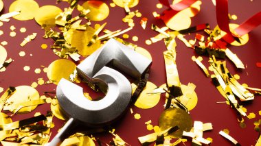 Kırmızı bayramda konfeti arkaplanlı 5 numaralı doğum günü rakamı. 5 'inci yaş günü. Doğum günü, yıldönümü ve tarih kavramı. yakın plan