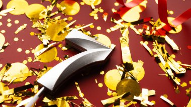 Konfeti arkaplanlı 7 numaralı kırmızı şenlik kutlamasında doğum günü rakamı. yedinci yaş günü. Doğum günü, yıldönümü ve tarih kavramı. yakın plan