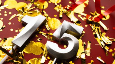 Kırmızı bayramda konfeti arkaplanlı 15 numaralı doğum günü rakamı. On beşinci yaş günü. Doğum günü, yıldönümü ve tarih kavramı. yakın plan