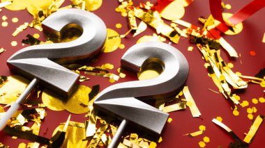 Kırmızı şenlik programında konfeti geçmişi olan 22 numaralı doğum günü rakamı. 22 'nci yaş günü. Doğum günü, yıldönümü ve tarih kavramı. yakın plan