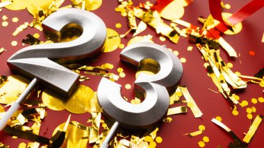 Kırmızı şenlikte konfeti arkaplanlı 23 numaralı doğum günü rakamı. 23 'üncü yaş günü. Doğum günü, yıldönümü ve tarih kavramı. yakın plan