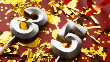 Konfeti geçmişi olan 35 numaralı kırmızı şenlik kutlamasında doğum günü rakamı. 35 'inci yaş günü. Doğum günü, yıldönümü ve tarih kavramı. yakın plan