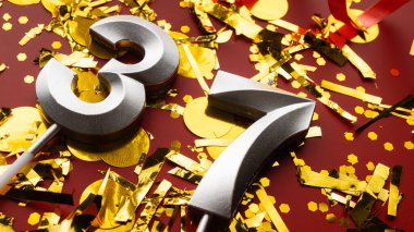 Konfeti arkaplanlı, Kızıl Şenlik 'te 37 numaralı doğum günü rakamı. Otuz yedinci yaş günü. Doğum günü, yıldönümü ve tarih kavramı. yakın plan