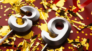 Kırmızı şenlik programında konfeti geçmişi olan 39 numaralı doğum günü rakamı. 39 'uncu yaş günü. Doğum günü, yıldönümü ve tarih kavramı. yakın plan