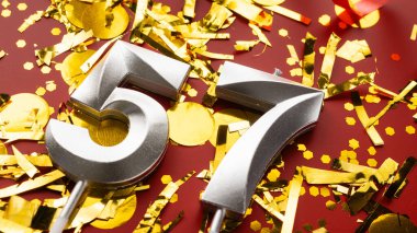 Kırmızı bayramda konfeti arkaplanlı 57 numaralı doğum günü rakamı. 57 'nci yaş günü. Doğum günü, yıldönümü ve tarih kavramı. Boşluğu kopyala