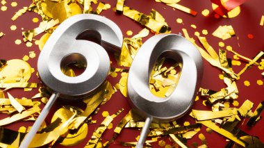 Kırmızı şenlik programında 60 numaralı doğum günü rakamı konfeti arka planında. Altmış yıllık doğum günü. Doğum günü, yıldönümü ve tarih kavramı. Boşluğu kopyala